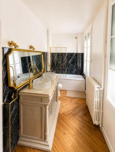a bathroom with two sinks and a tub at Chambre Oolong Familiale in Cormeilles