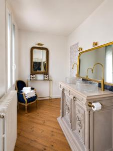 a bathroom with a sink and a mirror at Chambre Oolong Familiale in Cormeilles