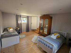 a small bedroom with two beds and a mirror at Chambre Oolong Familiale in Cormeilles