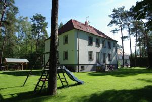 a house with a playground in front of it at CasaBlanca Biały Dom in Borne Sulinowo