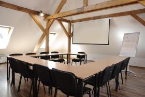 a meeting room with tables and chairs and a whiteboard at CasaBlanca Biały Dom in Borne Sulinowo