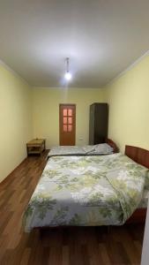 a bedroom with a large bed and a wooden floor at Гостевой дом Арай in Bosteri