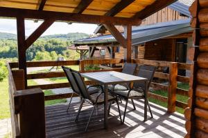 a table and chairs on the deck of a cabin at Timber Fairies in Slunj