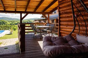 a deck with a table and chairs and a couch at Timber Fairies in Slunj