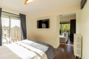 a bedroom with a bed and a tv on the wall at Logis Clair Matin Resort & Spa in Le Chambon-sur-Lignon