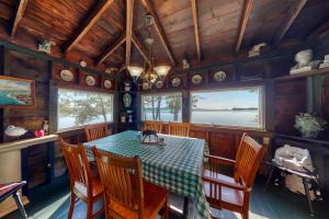 a dining room with a table with a cat sitting on it at Spacious Waterfront Estate & Cabins W/ Porch, Fireplace, Kayaks & Free WiFi in Brunswick +51 photos