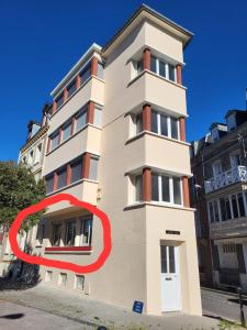 a tall white building with a red circle around it at L'arc-en-ciel in Le Tréport