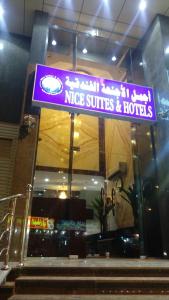 un letrero púrpura en la parte delantera de un hotel y suites de nopé en Nice Suites & Hotels, en La Meca