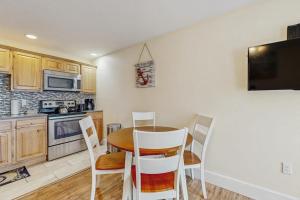 a kitchen with a table and chairs and a microwave at New Condo w/Water-View Deck in Edgecomb in Edgecomb +7 photos