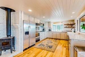 a kitchen with stainless steel appliances and a stove at Renovated oceanfront home with stunning view & pebbly beach - snowbird-friendly in Saint George +20 photos