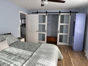 a bedroom with a bed and some sliding glass doors at Pura Vida | A Calm Apt Escape Minutes from Camden in Camden