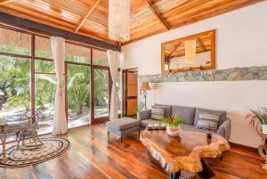 a living room with a couch and a table at Ocho Artisan Bungalows in Tamarindo