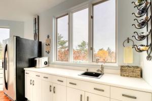 a kitchen with a refrigerator and a sink at Bayfront home with 270-degree views, large deck & porch - near Popham Beach in Phippsburg