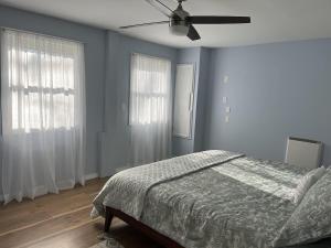 a bedroom with a bed and a ceiling fan at Pura Vida | A Calm Apt Escape Minutes from Camden in Camden