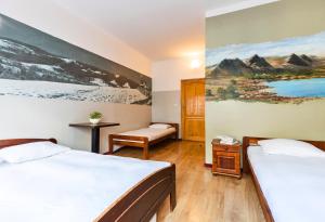 a bedroom with two beds and a painting on the wall at Top Hostel Pokoje Gościnne in Zakopane
