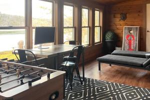 a living room with a table and a desk with chairs at Gorgeous Waterfront Home on Westport Island with 2 Sunrooms in Montsweag