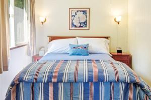 a bed with a blue pillow on top of it at Woodland Home near Long Pond w/ Spacious Living Area, Full Kitchen & Deck in Somesville +21 photos