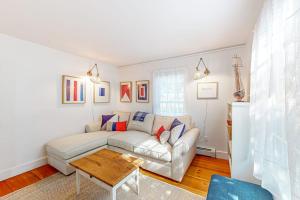 un soggiorno con un divano bianco e un tavolo di Elegant home right in town with gorgeous water view, deck & interior a Wiscasset