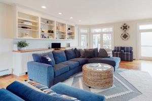 a living room with a blue couch and a table at Spectacular oceanfront retreat with amazing views, sunroom & washer/dryer in Georgetown