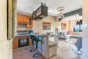 a kitchen with a bar with a tv above it at Atlas Views Appartements avec Piscine Golf de Marrakech in Marrakesh