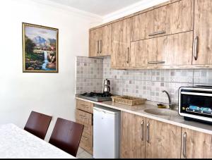 a kitchen with wooden cabinets and a sink at kozalak evleri in Gökbel