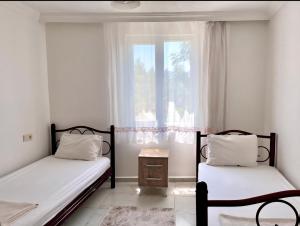 two beds in a room with a window at kozalak evleri in Gökbel