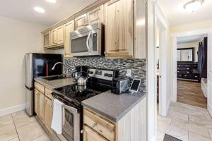a kitchen with a stove and a microwave at New Riverfront Condo in Sheepscot Harbour - Walk to Famed Seafood Eatery in Edgecomb