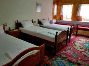 a bedroom with two beds and a rug at AmedaPm in Gjirokastër