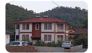 a house with two cars parked in front of it at İnlice Apart in Fethiye