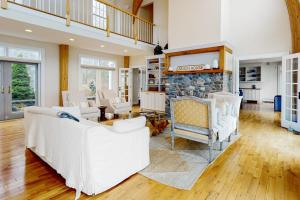 a living room with white furniture and a stone fireplace at Spectacular oceanfront retreat with amazing views, sunroom & washer/dryer in Georgetown +70 photos