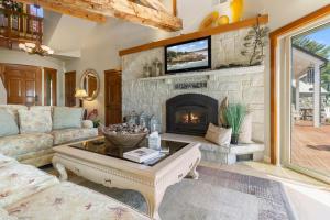 a living room with a couch and a fireplace at Elegant ocean view home with breathtaking views, private hot tub & large deck in Rockport