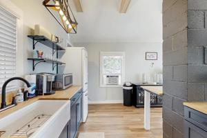 a kitchen with a sink and a white refrigerator at Charming cottage with a spacious deck overlooking the Megunticook River in Camden