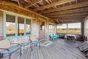 a porch with chairs and a table and windows at Peaceful coastal cabin with screened porch, water view of the cove, dog-friendly in Owls Head