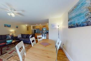 a living room with a table and a couch at Stylish Condo at Sheepscot Harbor Resort w/Free WiFi, River Views, & Balcony in Edgecomb