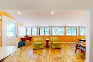 a living room with two chairs and a table at Waterfront home on St George River with private beach & deck - near festivals in Cushing