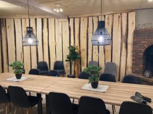 a conference room with a table and chairs and potted plants at Hotel Lokkilinna in Kalajoki