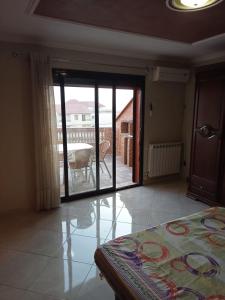a bedroom with a sliding glass door leading to a patio at Duplex pres de la mer a Alger in Rouiba