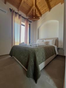 a bedroom with a large bed with a large window at Bella Villa in Proástion