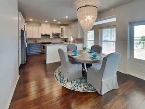a kitchen and dining room with a table and chairs at West Bay Getaway in Galveston