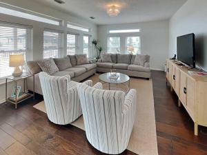 a living room with a couch and a tv at West Bay Getaway in Galveston