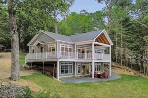 a large house with a wrap around porch at Elegant lakefront home near Bar Harbor & Acadia with modern kitchen, lake views in Orland