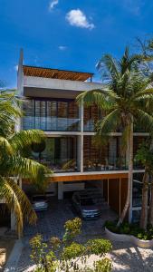 a house with palm trees in front of it at Luxury Beachfront 4BR PH in Bahia Soliman in Balcheil