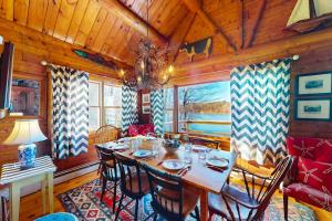a dining room with a table and chairs in a cabin at Riverfront retreat with a furnished deck, washer/dryer & fast WiFi in Boothbay