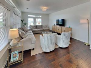 a living room with a couch and a tv at West Bay Getaway in Galveston