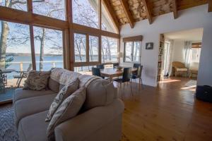 a living room with a couch and a table at Remodeled Waterfront Home with Wraparound Deck, Water Views, & Beach Access in Waldoboro