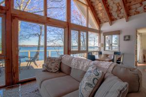 a living room with a couch and a view of the water at Remodeled Waterfront Home with Wraparound Deck, Water Views, & Beach Access in Waldoboro