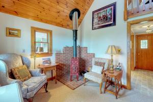 a living room with a fireplace and a couch and chairs at Beautiful hilltop home with deck & view of Penobscot Bay - near festivals & more in Rockport