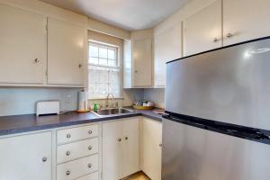 a kitchen with white cabinets and a stainless steel refrigerator at Lovely studio w/full kitchen/free WiFi- next to river/antique shops/restaurants in Wiscasset