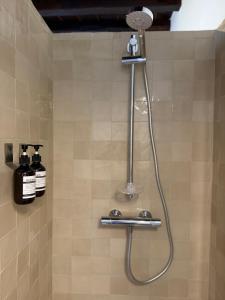 a shower with a shower head in a bathroom at Les chambres de Pierre in Arles
