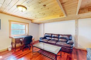 a living room with a leather couch and a table at Tranquil Haven | Secluded waterfront house with sauna, dock, kayaks, canoe, gym in Greenville